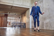 © Westend61 - Senior businessman skateboarding in his office