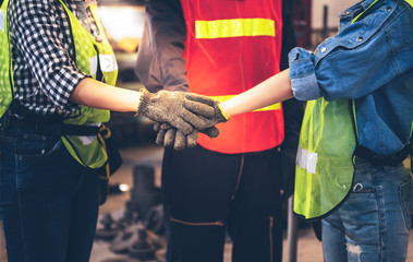 Wall Mural - Experienced entrepreneurs, engineers man and woman are join hands to show their cooperation For success teamwork, with blur soft of industrial machinery background, to people and synergy concept.