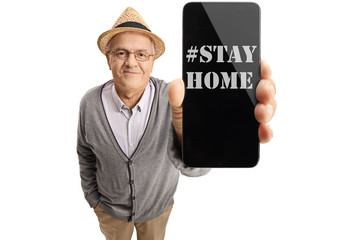 Wall Mural - Elderly man showing a phone with a text message stay home on the screen