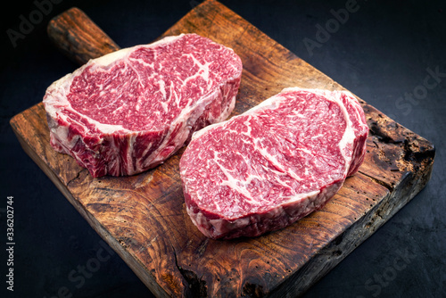 Cuadros en Lienzo 2 rohe dry aged Wagyu Entrecote Beefsteak als closeup auf einem rustikalen Holz