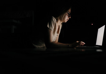 Mother and Daughter working with laptop at night at home.