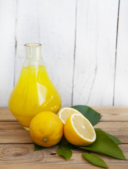 Wall Mural - Fresh lemonade in a glass jug with lemons on a wooden background