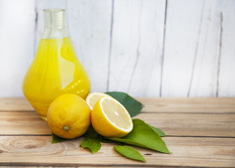 Wall Mural - Fresh lemonade in a glass jug with lemons on a wooden background