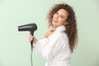 © Pixel-Shot - Beautiful young African-American woman with blow dryer on color background