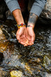 © Manu Prats/Stocksy - Mand hands about to scoop water from river