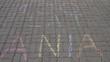 Napis zrobiony kredą na chodniku, w tłumaczeniu napis oznacza 