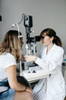 © Sergio Marcos/Stocksy - Female eye doctor examining patient using slim lamp modern equipment in clinic