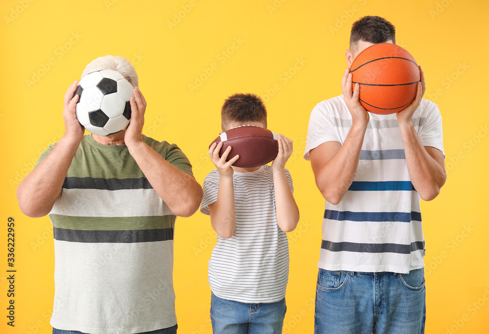 Man with his father and son holding different balls on color background