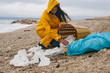 © Marija Kovac/Stocksy - Woman cleaning up a beach from plastic