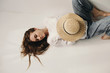 © Sergey Filimonov/Stocksy - Young female with hat lying on floor