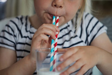 Child Drinking Milk Through A Paper Straw