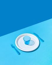 Set Of Plastic Tableware On A Double Blue Background