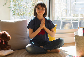 Wall Mural - smiling child in lockdown enjoying namaste while practicing relaxing yoga