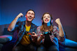 © bondvit - Portrait of crazy playful couple, Gamers enjoying Playing Video Games on Playstation indoors sitting on the sofa, holding Console Gamepad in hands, Xbox fans. Resting At Home, have a great Weekend