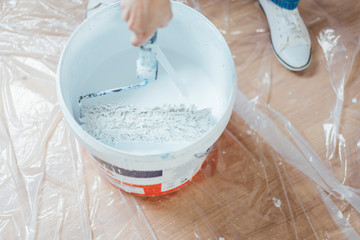 Tools and bucket of white paint.