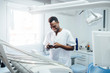 © Westend61 - Happy dentist using cell phone in his medical practice