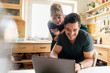 © Westend61 - Happy couple shopping online in kitchen at home