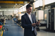 © Westend61 - Mature businessman using cell phone in a factory