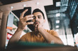 © BullRun - Serious  hipster guy checking mail via app on cellular sending messages on free time in cafe interior, pensive male blogger making transaction via smartphone concentrated on confirming access.