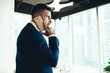 © BullRun - Successful male executive in suit talking on smartphone at office