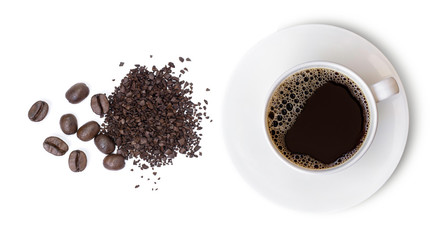 Wall Mural - Top view of cup of black coffee and beans on white.