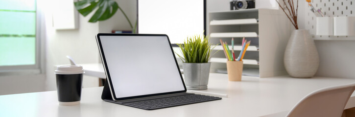 Cropped shot of portable office desk with mock-up computer devices, supplies and decorations