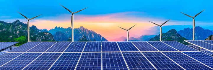 solar panels with wind turbines in the setting sun,green energy.