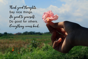 Inspirational quote - Think good thoughts. Say nice things. Be good to yourself. Do good for others. Everything comes back. With flower in hand on bright blue sky rural view background.