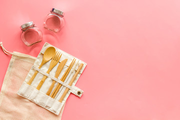 Wall Mural - Cotton eco bag and wooden tableware on pink background, top view. Zero waste, plastic free concept copy space