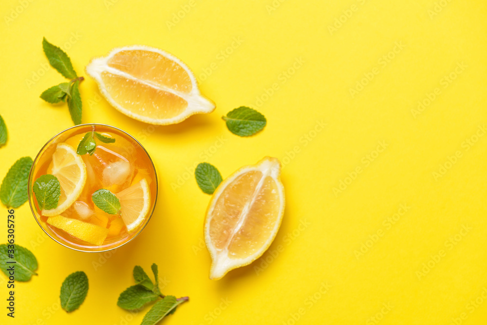 Glass of tasty cold ice tea on color background