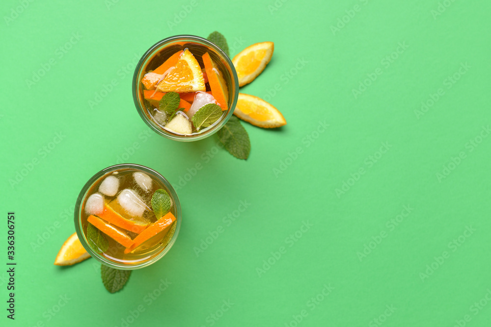 Glasses of tasty cold ice tea on color background