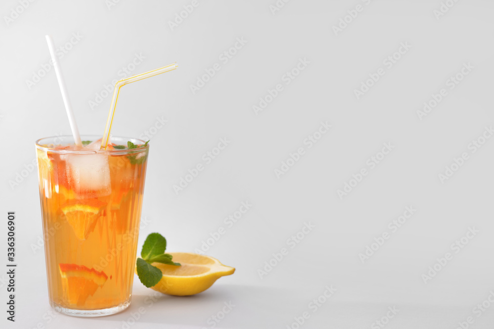 Glass of tasty cold ice tea on grey background