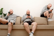 Collage of male cloned sits on the couch in various poses and uses a smartphone. Composite of multiple Human clones doing different activities at home during lockdown due to COVID pandemic