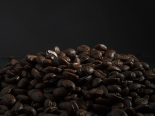 Brown roasted coffee beans, seed on dark background. Espresso dark, aroma, black caffeine drink. Closeup energy mocha, cappuccino ingredient