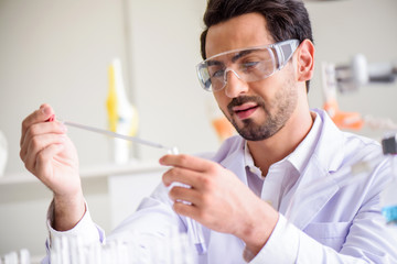 Wall Mural - attractive happiness scientist man lab technician assistant analyzing sample in test tube at laborat
