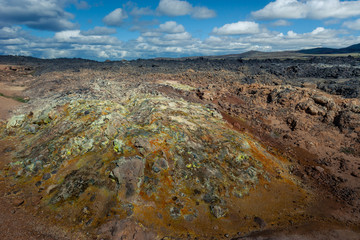 Beautiful colourful Icelandic landscape lava fields mountain geysers zigzag road and moss-covered stones Namafjall, Iceland.