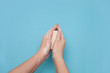 Hands using hygiene antiseptic soap on a blue background overhead top view 