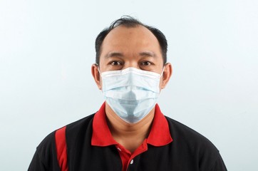 Close up of asian man's face wearing medical face mask to protect himself from Covid-19 virus, health protection concept.