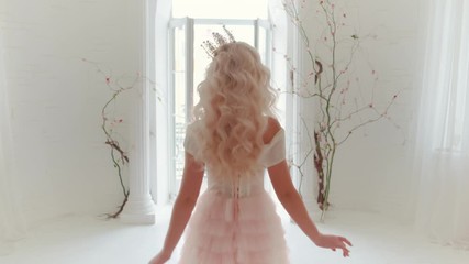 Wall Mural - Young beautiful blond woman princess. Curly loose hair chic medieval crown. Long pink luxury lush vintage dress. Backdrop white interior room multicolored balloons, black tree branches. Rear view back