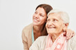 Frau und Senioren schauen zuversichtlich lächelnd
