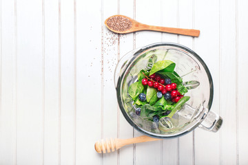 Wall Mural - Blender with ingredients for healthy smoothie on wooden background