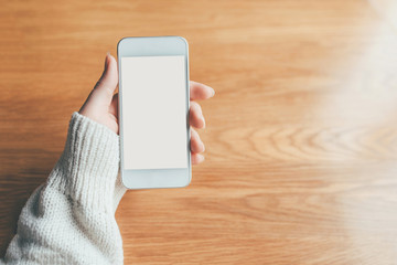 Woman's hand holding phone with white screen. Copy space for your text message.