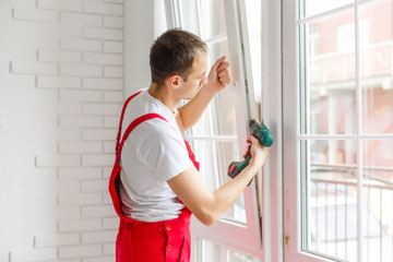 Construction worker installing new window in house