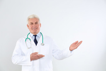 Poster - Portrait of senior doctor with stethoscope on white background