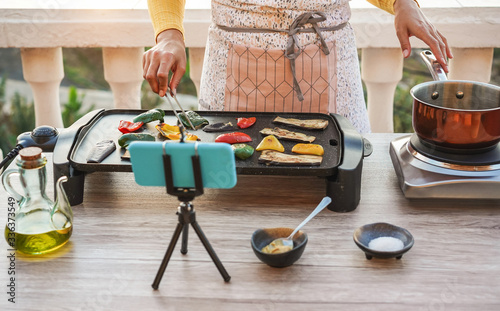 Young woman chef cooking outdoor while streaming online for webinar masterclass Tableau sur Toile