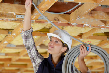 female plumber fixing pipe at construction site