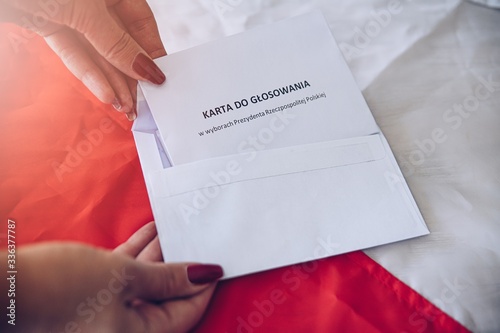 Fotografía Woman putting correspondence postal ballot paper to envelope.