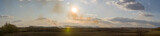 Fototapeta Tęcza - Panorama of clouds at sunset. You can see how the fields burn.