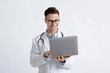© Prostock-studio - Smiling doctor in glasses and laptops in hands