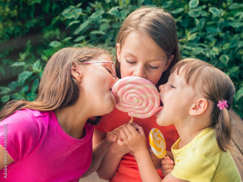 group of little girls licking lollipop 